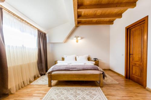 a bedroom with a bed and a large window at Dacii Liberi Resort and Spa in Petrova