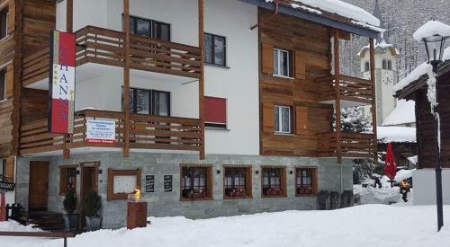 a building with snow on the ground in front of it at Apart-hotel Channa in Saas-Almagell