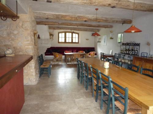 un comedor con una mesa larga y sillas en La Ferme du petit Ségriès Bed and Breakfast, en Moustiers-Sainte-Marie