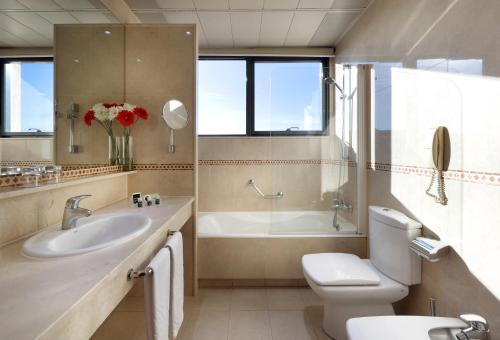 馬德里的住宿－埃克廣場酒店，浴室配有盥洗盆、卫生间和浴缸。