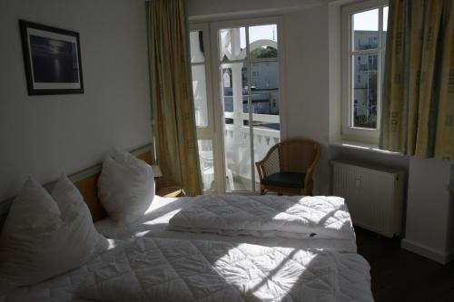 オストゼーバート・ゼリンにあるFerienwohnung in Sellin _ Seeparkのベッド2台と窓が備わるホテルルームです。