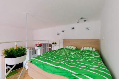una camera da letto con un grande letto verde con due cuscini di F4 Fiumei Apartment a Budapest