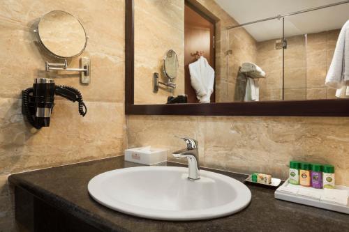 a bathroom with a sink and a mirror at Ramada Jamshedpur Bistupur in Jamshedpur