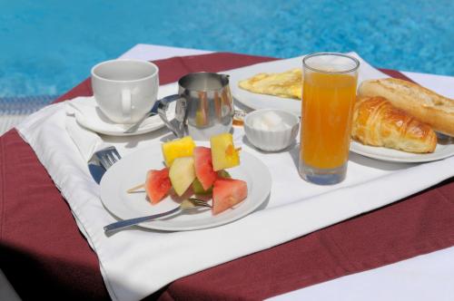 a table with two plates of food and a glass of orange juice at Residence Eburnea in Abidjan