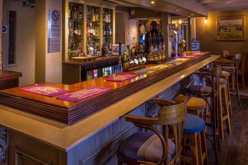 a bar with a wooden counter and some bar stools at Kings Arms in Penzance