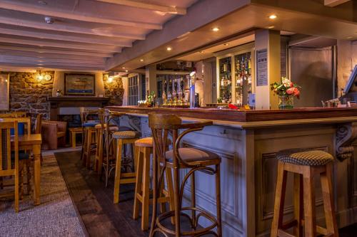 a bar with wooden stools in a restaurant at Kings Arms in Penzance