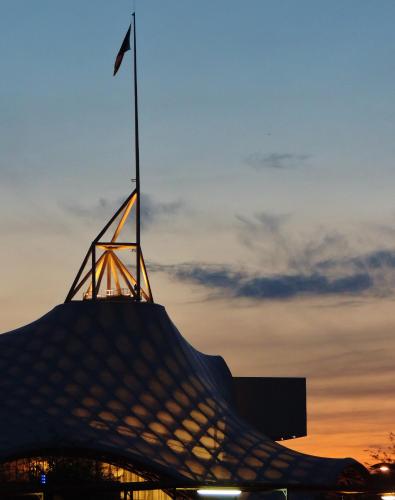 a flag on top of a building at sunset at Campanile Metz Centre - Gare in Metz