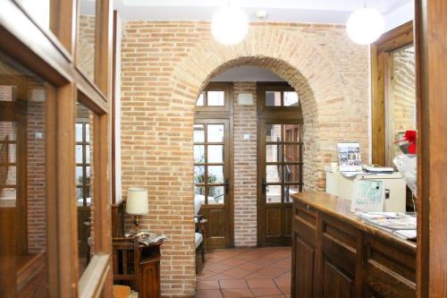 una cocina con una pared de ladrillo y un arco en San Miguel, en Segovia