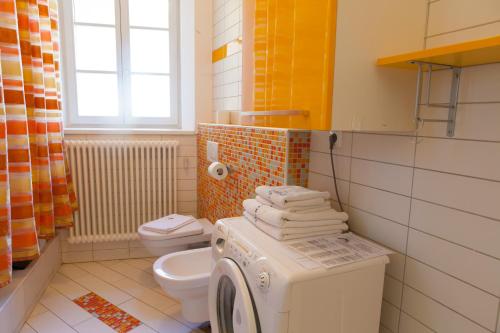 a bathroom with a washing machine and a toilet at Rimska Apartments Tour As Ljubljana in Ljubljana