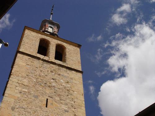 
a tall tower with a clock on it's side at San Miguel in Segovia
