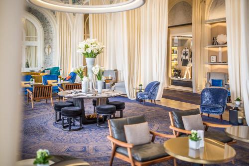a hotel lobby with a table and chairs at Hôtel Royal in Évian-les-Bains