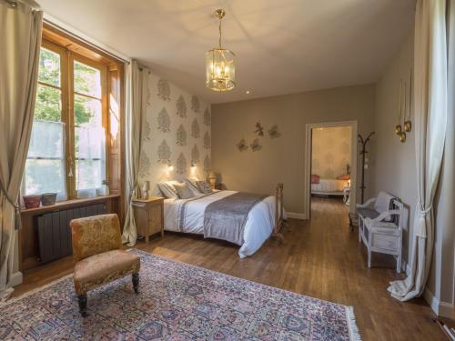 a bedroom with a bed and a chair at Manoir Tregont Mab in Quimper