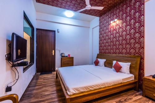 a bedroom with a bed and a television in it at Sia Resort in Nagaon