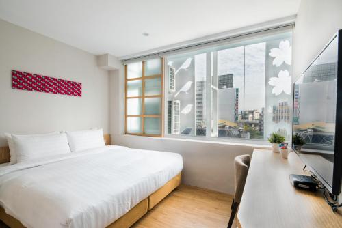 a bedroom with a bed and a large window at Shin Sei Bashi Hotel in Taichung