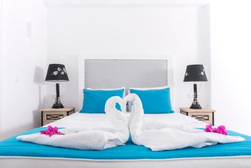 two white swans are sitting on a bed at Blue Waves Suites & Apartments in Kamari