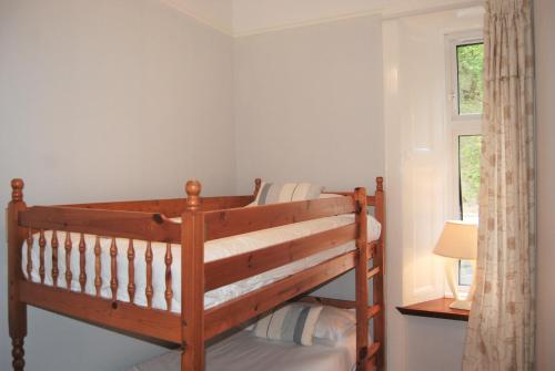 a bedroom with a wooden bunk bed with a window at Kingswood Hotel in Burntisland