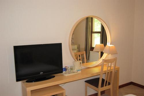 a television sitting on a desk with a mirror at Kingswood Hotel in Burntisland