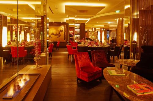 a restaurant with red chairs and tables in a room at Savoy Hotel in Cologne