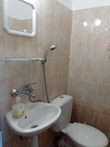 a bathroom with a sink and a toilet and a mirror at Stai Za Gosti Venera in Hisarya