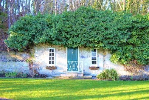 a stone house with a blue door and a large bush at Kingswood Hotel in Burntisland