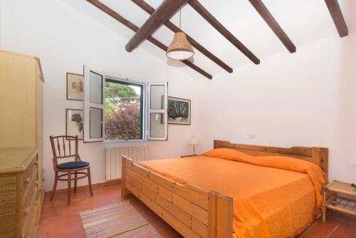 ポルトフェッラーイオにあるCasa Marchini - Goelbaのベッドルーム1室(ベッド1台、椅子、窓付)