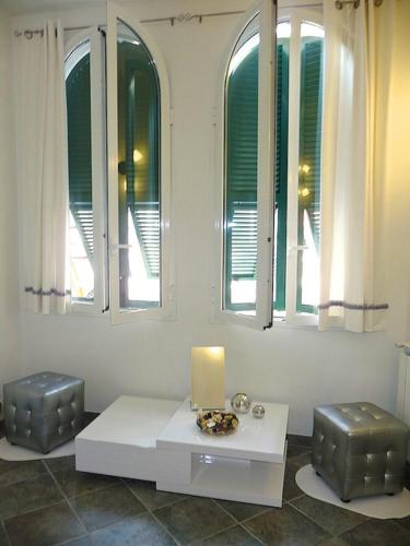 a room with a table and two stools and windows at Cegi's home in Vernazza