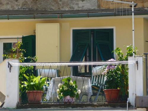 a balcony with two chairs and potted plants on it at Cegi's home in Vernazza