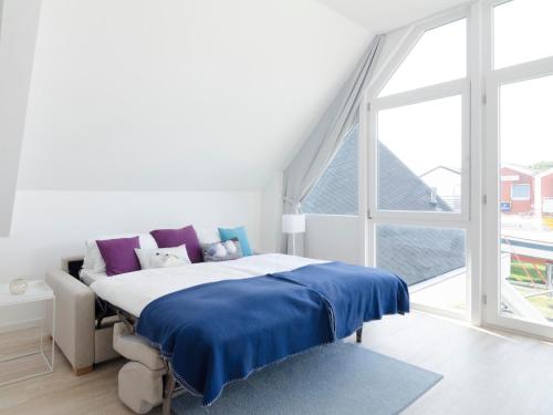 a bedroom with a bed and a large window at Haus Marinas in Helgoland