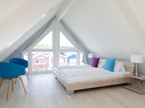 Un dormitorio blanco con una cama y una ventana grande. en Haus Marinas, en Helgoland