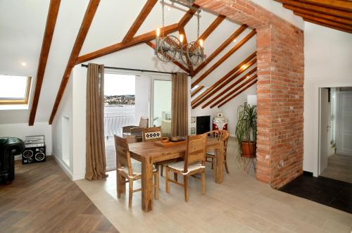 a dining room with a wooden table and a brick wall at Apartment Holiday in Podstrana in Podstrana