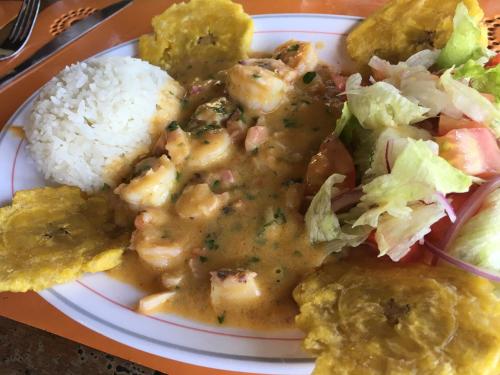 a plate of food with shrimp and rice and a salad at Hosteria Cumilinche in Same