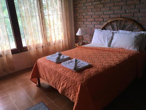 a bedroom with a bed with two towels on it at Hosteria Cumilinche in Same