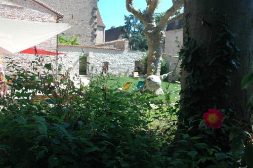 a garden with a statue of a dog in the yard at Le Clos de l'Abbaye in Cluny
