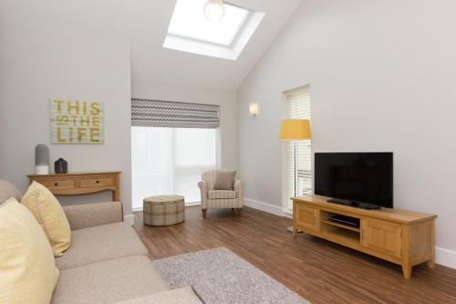 a living room with a couch and a flat screen tv at Citystay Living - The Dales in Cambridge