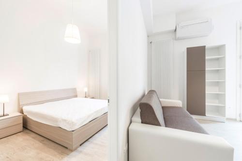 ボローニャにあるMura, Bologna by Short Holidaysの白いベッドルーム(ベッド1台、ソファ付)