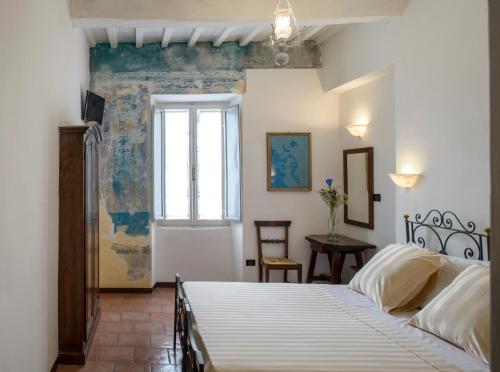 a bedroom with a white bed and white walls at Hotel Porta Marmorea in Gubbio