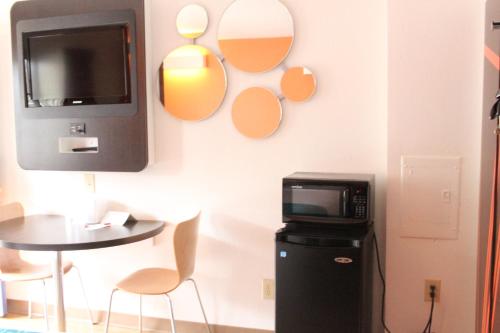 a room with a tv and a table and a microwave at Howard Johnson by Wyndham Lake George in Lake George