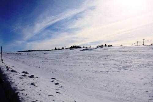 a snow covered field with the sun in the sky at Apartmány Cestář Boží Dar in Boží Dar