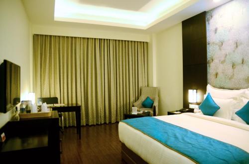 a hotel room with a bed and a desk at Ramada Jamshedpur Bistupur in Jamshedpur