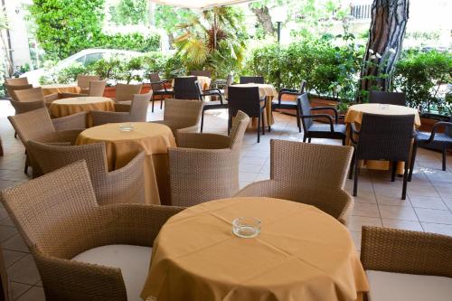 un restaurante vacío con mesas y sillas y un registrador en Hotel Gabbiano, en Riccione
