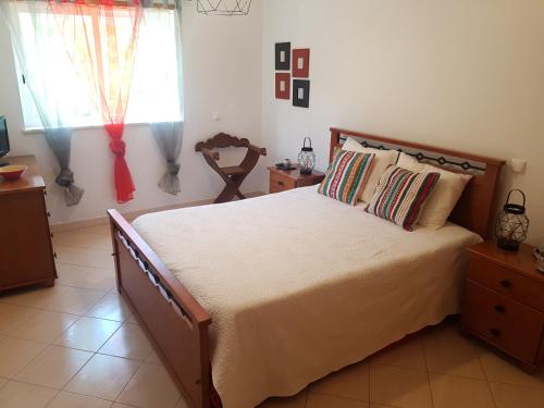 um quarto com uma cama grande e uma janela em Apartamento Silva em Albufeira