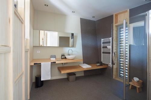 a bathroom with a sink and a mirror and a shower at Les Échasses Golf & Surf Eco Lodge in Saubion