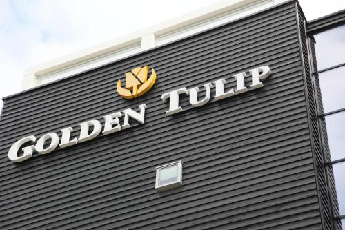 a sign on the side of a building with a golden turnip at Golden Tulip Zoetermeer - Den Haag in Zoetermeer