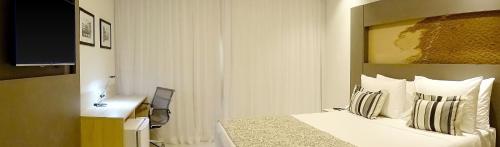 a hotel room with a bed and a desk at TRYP by Wyndham Manaus Aeroporto in Manaus