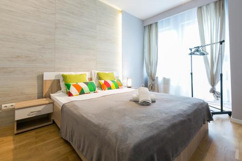 a bedroom with a large bed with colorful pillows at VIP Apartamenty Stara Polana 2 in Zakopane
