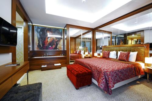 a hotel room with a bed and a television at Ramada by Wyndham Podgorica in Podgorica