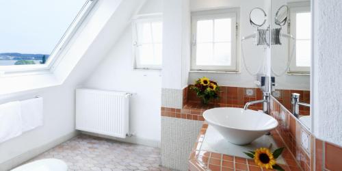 a white bathroom with a sink and a window at Insel-Hof Reichenau Hotel-garni in Reichenau