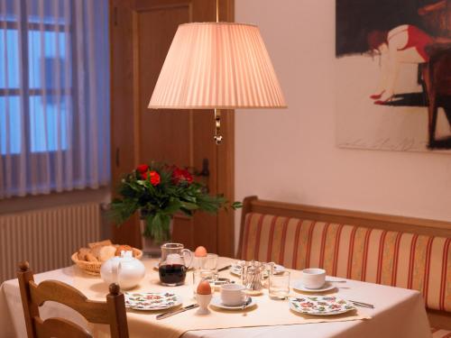 a table with a lamp and a table with plates and cups at Chalet Kerber in Lech am Arlberg
