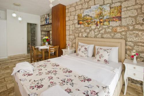 a bedroom with a bed and a stone wall at İncekara in Alaçatı