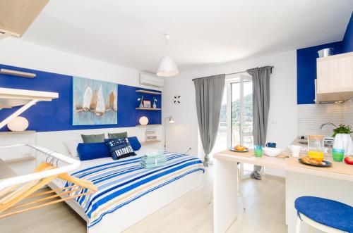 Apartments Zore Glavinić في دوبروفنيك: غرفة نوم زرقاء وبيضاء مع سرير ومكتب